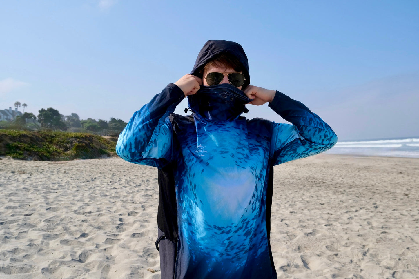 Angler 24-7 fishing shirt with cover face on beach.
