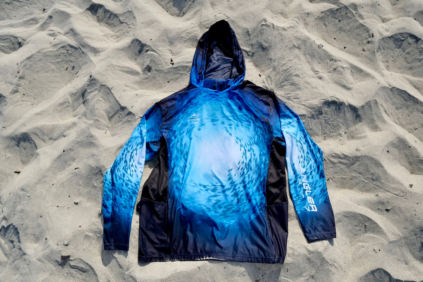 Angler 24-7 fishing shirt on beach.